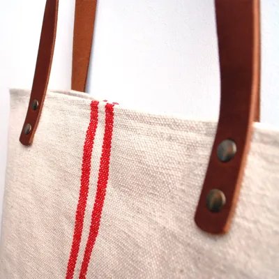 Bolsa rústica rayas rojas asas piel detalle